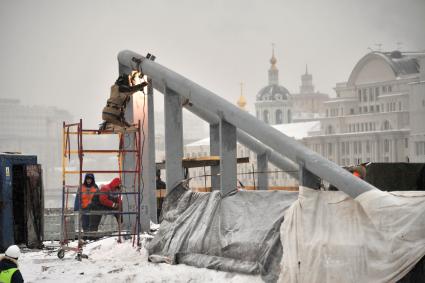 Москва. Рабочие монтируют опоры парящего моста на территории парка `Зарядье` на месте снесенной гостиницы `Россия`.