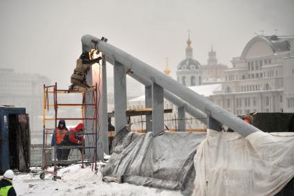 Москва.  Рабочие монтируют опоры парящего моста на территории парка `Зарядье` на месте снесенной гостиницы `Россия`.