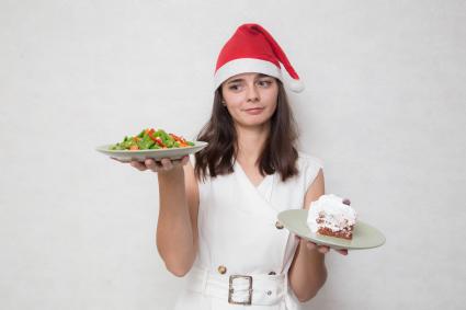 Челябинск. Девушка держит в руках тарелку с замороженными овощами и тарелку с тортом.