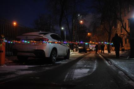 Москва.  Светящаяся гирлянда на шлагбауме во дворе жилого дома.