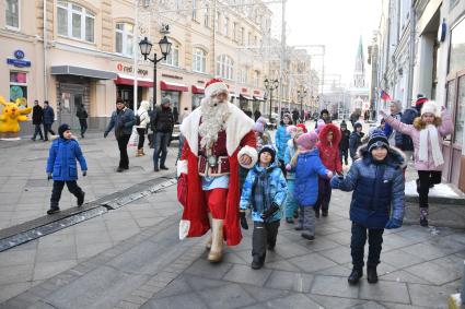 Москва. Дед Мороз на прогулке с детьми на Никольской улице.