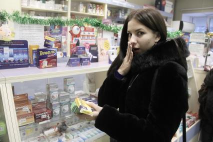 Нижний Новгород. Девушка выбирает лекарство в аптеке.