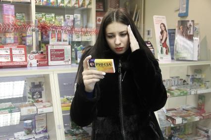 Нижний Новгород. Девушка выбирает лекарство в аптеке.