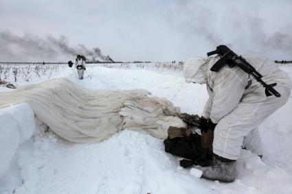 Рязанская область. Военнослужащий 106-й гвардейской Воздушно-десантной Краснознаменной ордена Кутузова дивизии   складывает парашют после приземления.