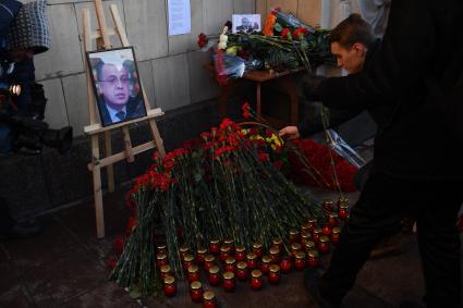 Москва. Мужчина возлагает цветы к портрету  погибшего в Турции дипломата Андрея Карлова у здания МИДа на Смоленской-Сенной площади.