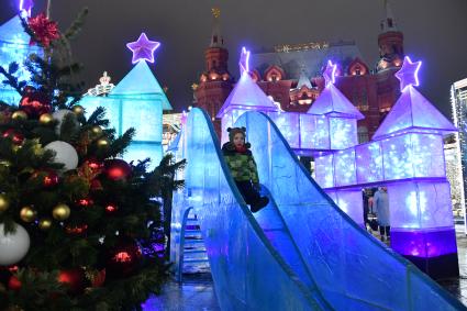 Москва. Девочка катается с горки  на Манежной площади.