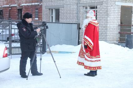 Нижний Новгород.  Сотрудник полиции снимает на камеру   мужчину в костюме Деда Мороза.