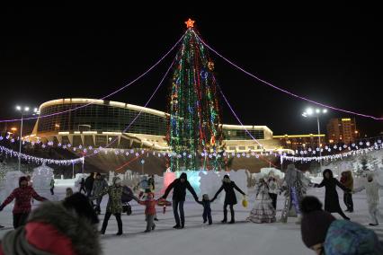 Уфа.   Взрослые и дети водят хоровод у новогодней елки.