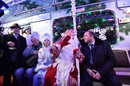 Москва. Дед Мороз и Снегурочка из Великого Устюга и глава московского метрополитена Дмитрий Пегов (справа) в новогоднем поезде метро на Кольцевой линии.