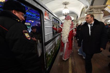 Москва. Дед Мороз из Великого Устюга и глава московского метрополитена Дмитрий Пегов (справа) на презентации новогоднего поезда метро на Кольцевой линии.