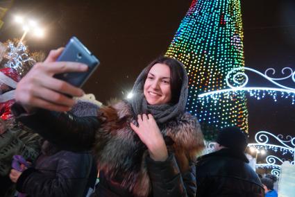 Екатеринбург. Девушка фотографируется на фоне главной городской елки. Открытие ледового городка на площади 1905 года