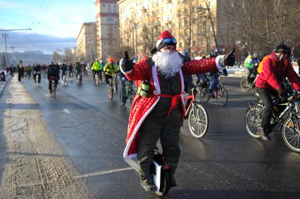 Москва.  Участник Второго зимнего Московского Велопарада в костюме Деда Мороза на моноколесе.