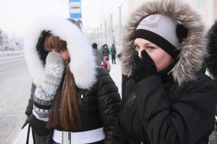 Барнаул. Девушки на улице  закрывают лица от холода.