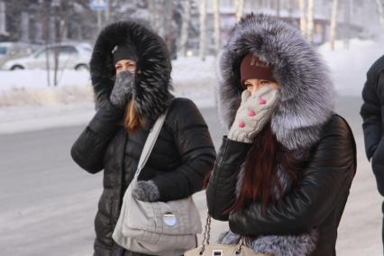 Барнаул. Девушки на улице  закрывают лица от холода.