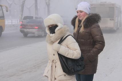 Барнаул. Девушка на улице  закрыла лицо от холода.