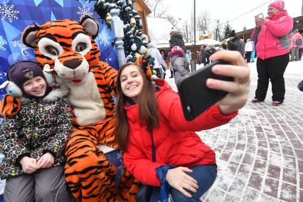 Москва. Девочка фотографируется с ростовой куклой Тигр в усадьбе Деда Мороза в Кузьминках.