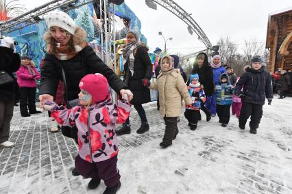 Москва. Родители и дети играют на площади  в усадьбе Деда Мороза в Кузьминках.