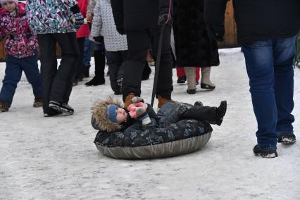 Москва.   Ребенок сидит в тюбинге.