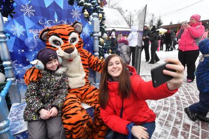 Москва. Девочка фотографируется с ростовой куклой Тигр  в усадьбе Деда Мороза в Кузьминках.