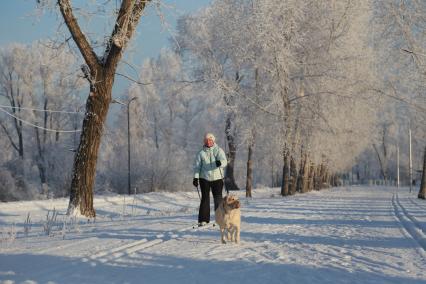 Красноярск. Женщина катается на лыжах в парке.