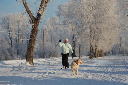 Красноярск.  Женщина катается на лыжах в парке.