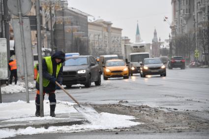 Москва.   Сотрудник коммунальных служб убирает снег на Тверской улице.