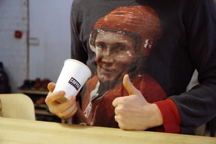 Екатеринбург. Мужчина с фотографией президента России Владимира Путина на джемпере, пьет кофе в одной из кофеен города