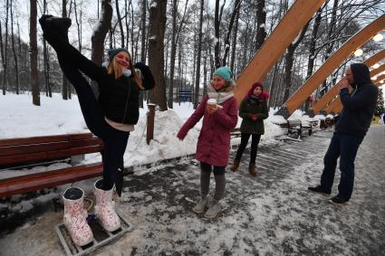 Москва. Девочка греет  ноги в термоваленках, которые установили в парке `Сокольники`на Аллее арок.