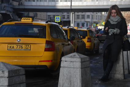 Москва. Девушка вызывает такси при помощи приложения, установленного в планшете.