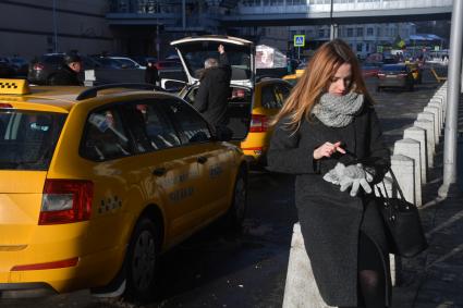 Москва. Девушка вызывает такси при помощи приложения, установленного в планшете.