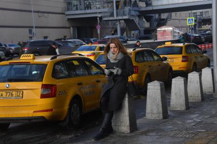 Москва. Девушка вызывает такси при помощи приложения, установленного в планшете.