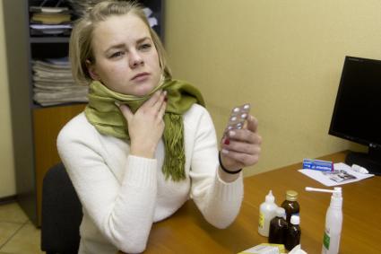 Иркутск. Девушка на рабочем месте в офисе лечит простуду.
