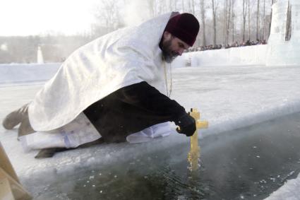 Иркутск. Священнослужитель  освящает воду в иордани  перед крещенскими купаниями.