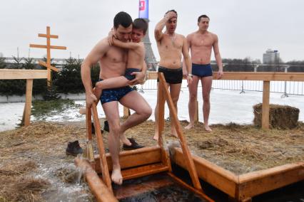 Москва. Мужчина с мальчиком  во время крещенского купания на Останкинском пруду.