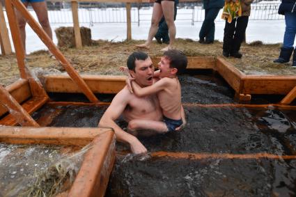 Москва. Мужчина с мальчиком  во время крещенского купания на Останкинском пруду.