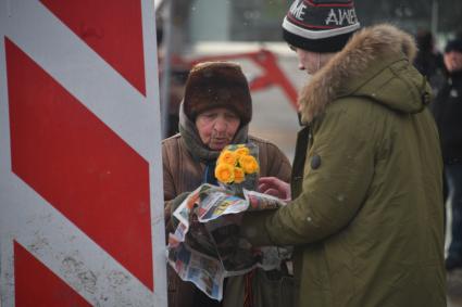 Москва. Пожилая женщина продает цветы.