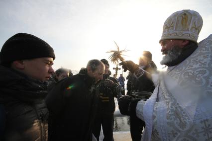 Уфа.  Священнослужитель окропляет святой водой верующих  в день празднования Крещения господня.