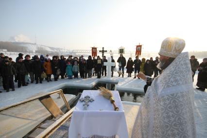 Уфа. Священнослужитель окропляет верующих святой водой во время празднования Крещения Господня.