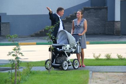 Нижний Новгород. Мужчина и женщина с детской коляской  во дворе жилого дома.