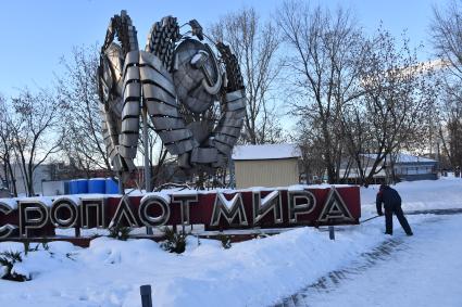 Москва. Сотрудник коммунальных служб убирает снег у скульптуры `СССР оплот мира` в музее под открытым небом `Музеон`.