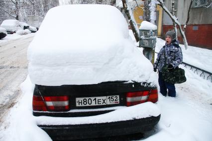 Нижний Новгород. Заснеженный автомобиль  во дворе жилого дома.