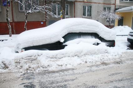 Нижний Новгород. Заснеженный автомобиль во дворе жилого дома.