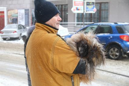 Нижний Новгород. Мужчина держит на руках  собачку.