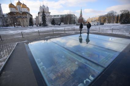 Москва. Туристы на Ивановской площади Кремля у архиологического окна .