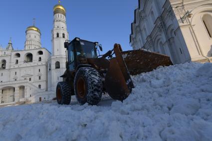 Москва.  Уборка снега на соборной площади Кремля у колокольни Ивана Великого.