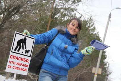 Челябинск.  Девушка у таблички `Спасибо, что убрали за собакой`.