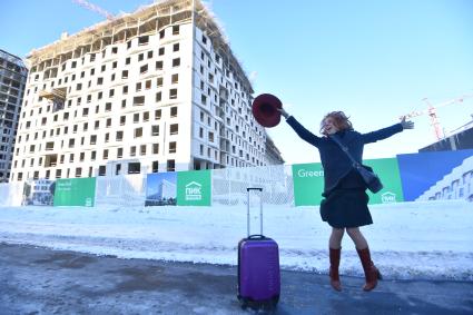 Москва.  Девушка с чемоданом  рядом с новостройкой.