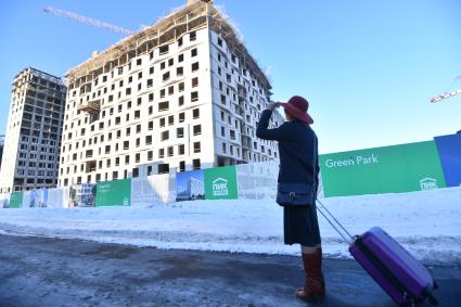 Москва.  Девушка с чемоданом  рядом с новостройкой.