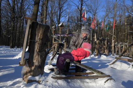 Москва. Женщина с ребенком во время прогулки на спортивной площадке с самодельными тренажерами в Тимирязевском парке.