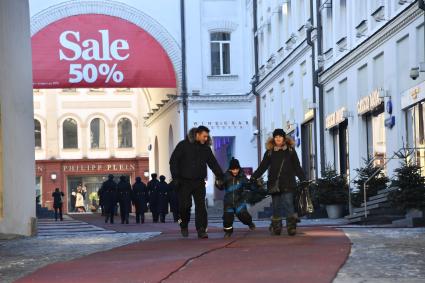 Москва.  Мужчина и женщина с ребенком в Третьяковском проезде.